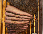 Sliced smoked Nebraska brisket on a wooden cutting board